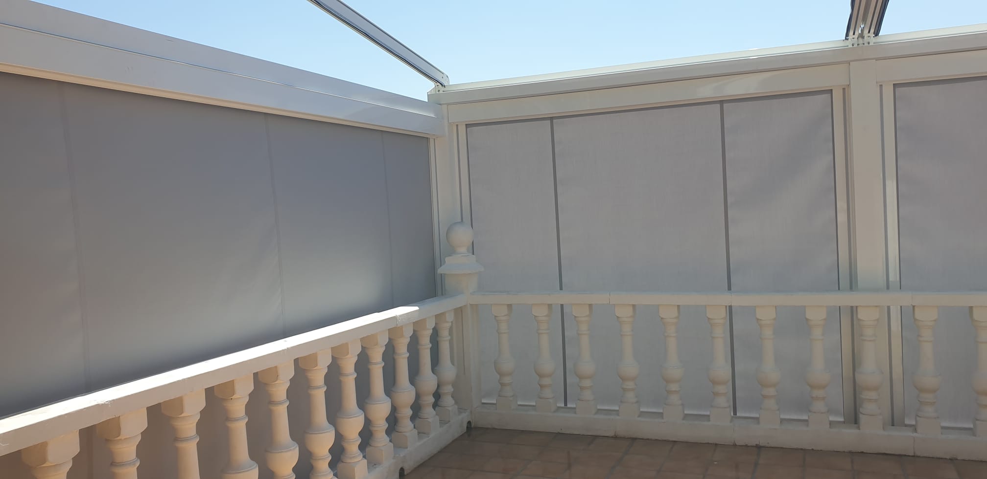 Toldos verticales grises para proteger una terraza lateral