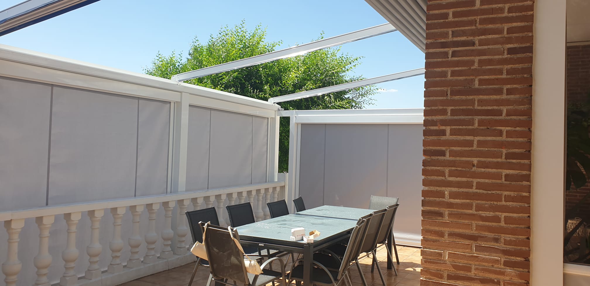 Pérgola tensada con la lona recogida para dejar abierta la cubierta