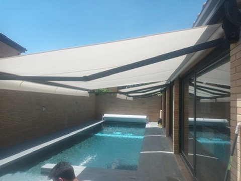 Toldos desplegados sobre una terraza junto a piscina