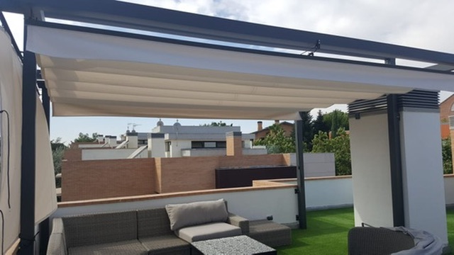 Pérgola de lona sobre zona de sofás en terraza