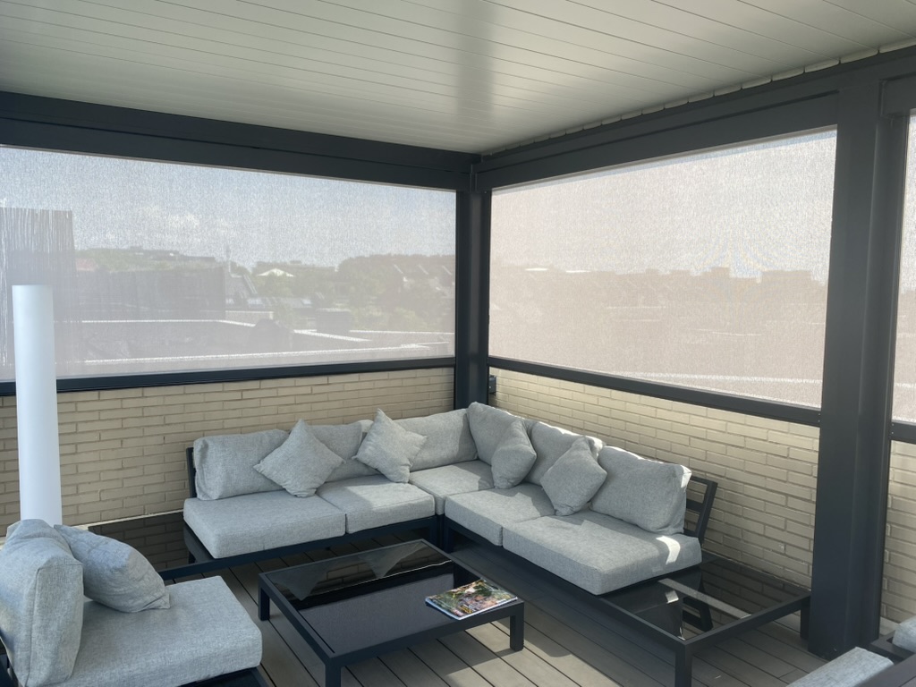 Interior de pérgola bioclimática con toldos verticales y zona de estar