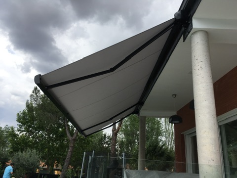 Toldo extensible instalado junto a un porche