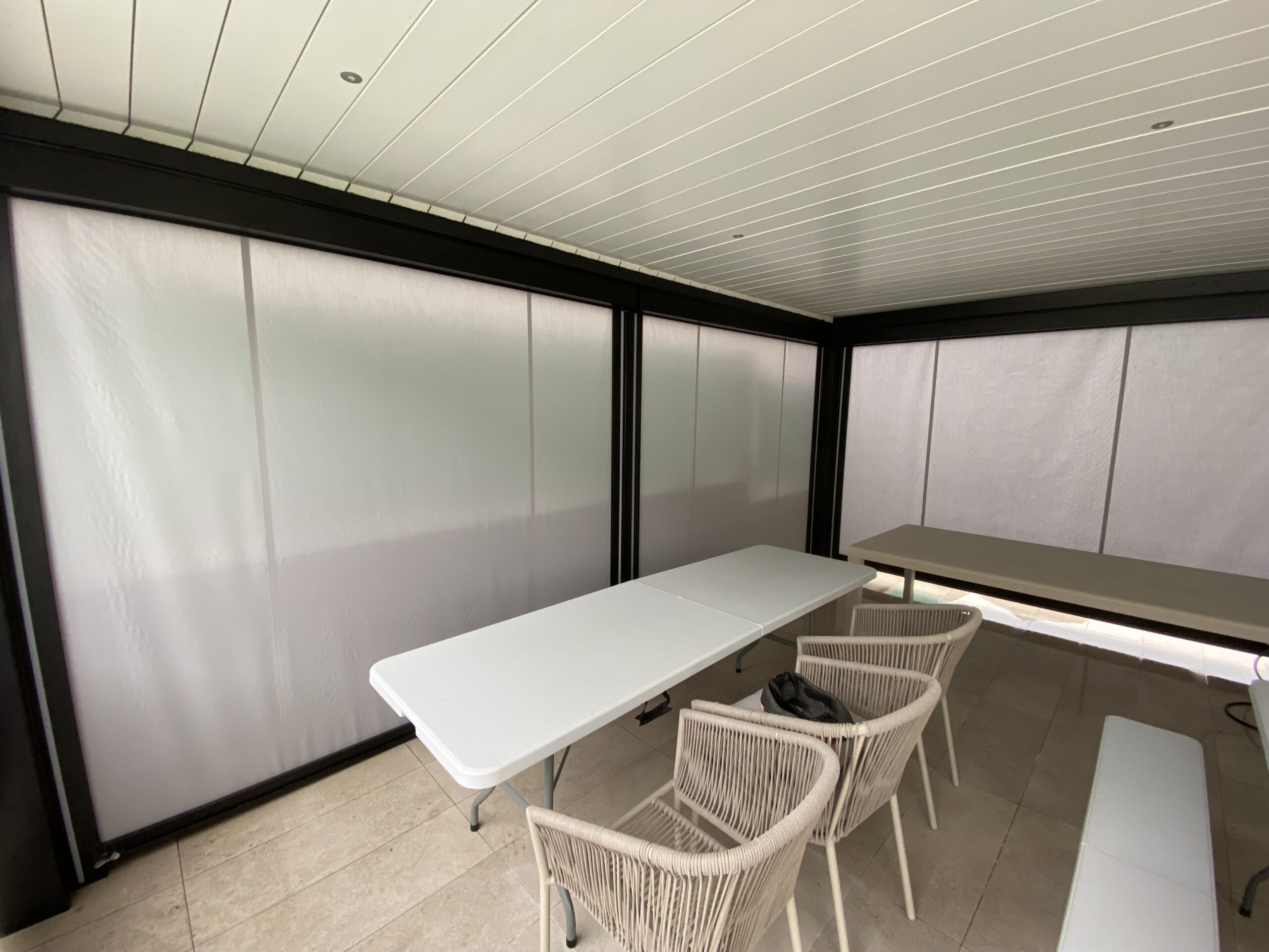 Detalle de los toldos verticales desplegados bajo la pérgola bioclimática de Valdemoro