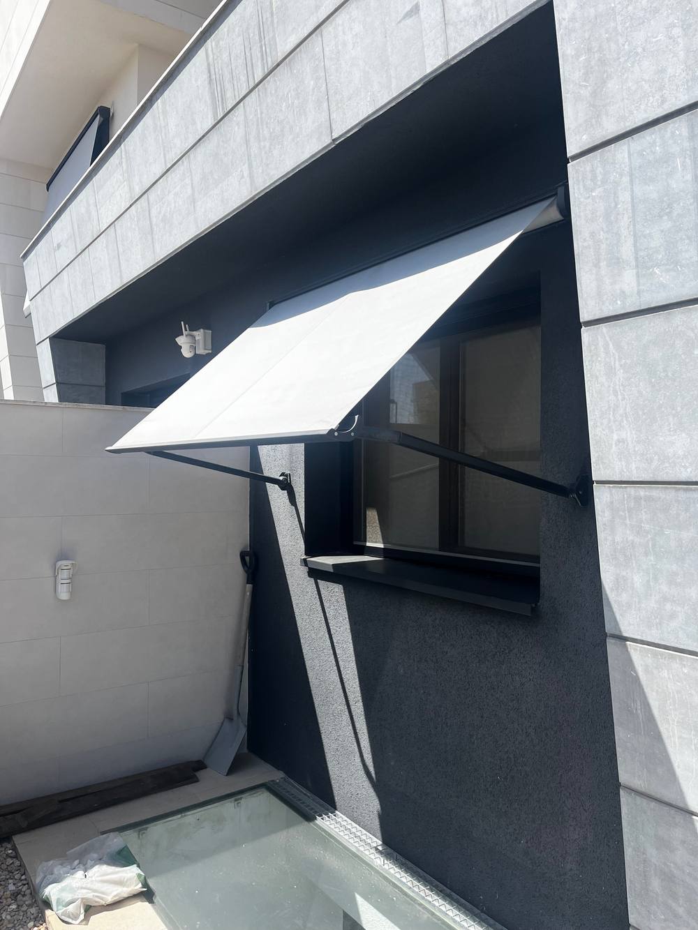 Toldo de brazos para una ventana, instalado en fachada